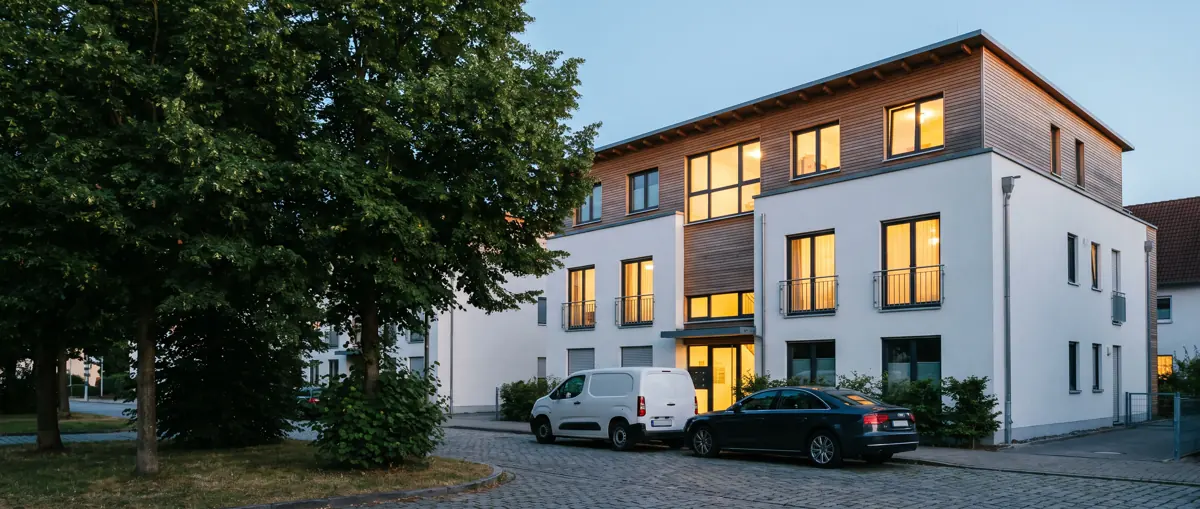 Mehrfamilienhaus mit Transporter vor der Tür